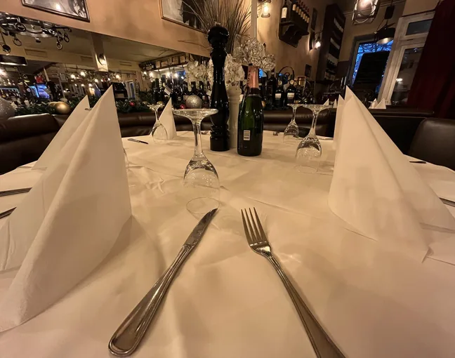 Gedeckter Tisch mit Stoffservietten und Besteck im Il Carpaccio